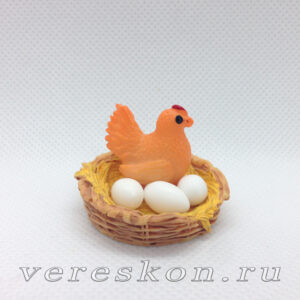 Рыжая курица и яйца в гнезде