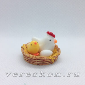 Белая курица с цыплёнком и яйцом в гнезде